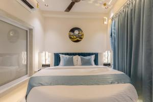 a bedroom with a large bed with blue curtains at Hotel Windsor Castle in Mumbai +38 photos