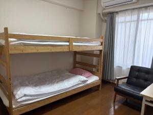 a bedroom with two bunk beds in a room at kotobuki504condotel in Imai-kamichō