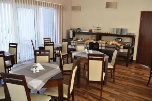 a dining room with tables and chairs and a kitchen at Valor in Grzybowo