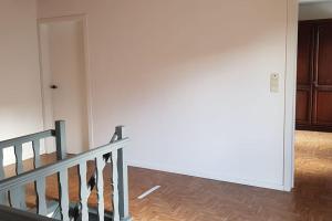 a room with a staircase and a white wall at Xiu's home in Wielsbeke