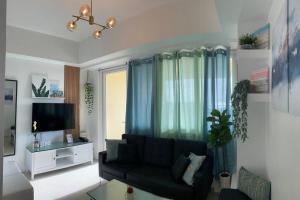 a living room with a couch and a tv at 2 Bedroom Mactan Beach Condo, La Mirada Residences in Lapu Lapu City