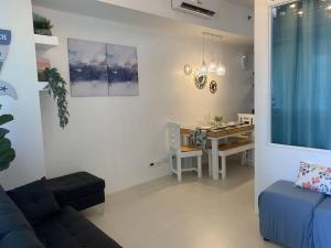 a living room with a couch and a dining room table at 2 Bedroom Mactan Beach Condo, La Mirada Residences in Lapu Lapu City