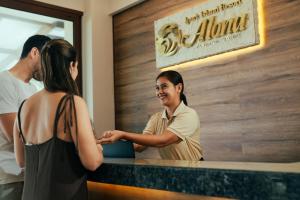 uma mulher parada num balcão a falar com uma mulher em Alona by Jpark Island Resort em Panglao City