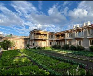 a large building with a garden in front of it at Leh Stumpa in Leh