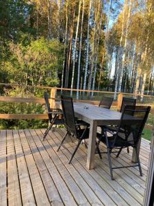a wooden deck with a wooden table and chairs at Ta det lugnt in Råda