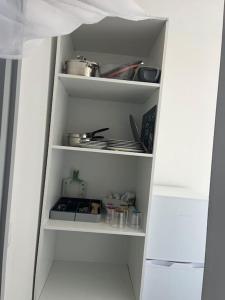 un meuble de cuisine blanc ouvert avec des aliments dessus dans l'établissement Au calme Proche centre ville, jardin et commodités, à Bourges 1 autre photo