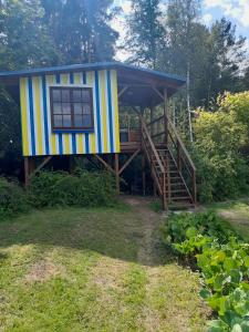 a small house with a staircase and a porch at Tree House Fluffy Horns - Namiņš Kokos Pūkainie Ragi in Plieņciems
