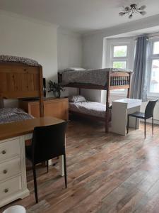 Zimmer mit 2 Etagenbetten sowie einem Tisch und Stühlen in der Unterkunft Family friendly house in Purley