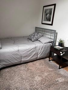 ein Bett in einem Schlafzimmer mit einem Nachttisch und einem Bett sidx sidx in der Unterkunft Family friendly house in Purley