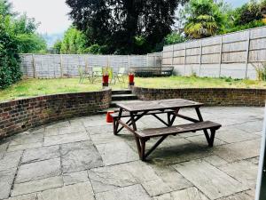 einem Picknicktisch und Bänken auf einer Terrasse in der Unterkunft Family friendly house in Purley