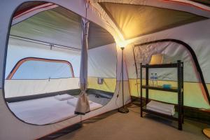 ein kleines Zelt mit einem Bett und einem Regal darin in der Unterkunft Sawasdee Lagoon Camping & Restaurant in Ban Lam Pi