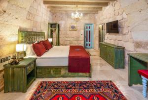 a bedroom with a bed and a tv in a room at Han Cave Suites - The Special Class in Göreme
