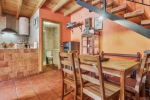 Una cocina y un comedor con mesa y sillas de madera. en Entre Valles, en Benllera 26 fotos más