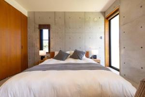 Postel nebo postele na pokoji v ubytování オーシャンビューの新築インテリアデザインを貸切!!テラス付きの宿で最高の休日をお楽しみください