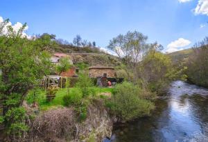 una casa en la cima de una colina junto a un río en Entre Valles, en Benllera