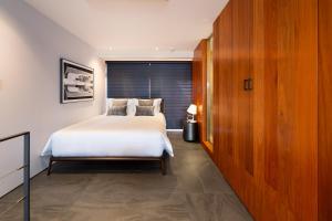 a bedroom with a white bed and a large window at Miya Townhouse by Reflections in Kyoto