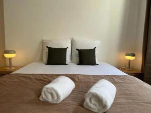 ein Bett mit zwei weißen Handtüchern darauf in der Unterkunft Chic 4 personnes Hypercentre 5 Minutes Avenue De Champagne in Épernay