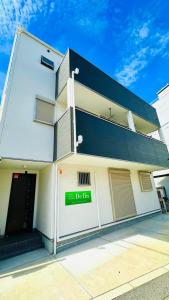 a white building with a sign that reads debt bin at DeL'm 難波から徒歩圏内京都奈良universal studio 関西空港まで交通便利無料駐車場付き in Osaka