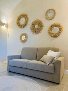 a living room with a couch and three mirrors on the wall at Apartment Antiche Mura in Specchia +6 photos