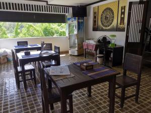 a room with wooden tables and chairs and a kitchen at บ้านอันดามัน กระบี่ in Krabi