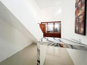 a white room with a staircase and a window at Urbanview Hotel Dommy Yogyakarta by RedDoorz in Ngabean