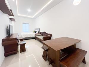 a living room with a table and a couch at Urbanview Hotel Dommy Yogyakarta by RedDoorz in Ngabean +64 photos
