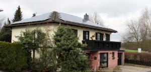 uma casa com um telhado com painéis solares em Ferienwohnung Diester Riegelsberg em Walpershofen