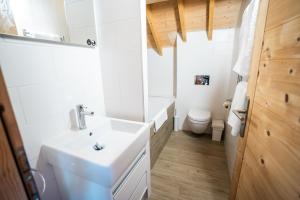 a white bathroom with a sink and a toilet at Chalet des Cousins: Fantastic alpine chalet in Vaujany +24 photos