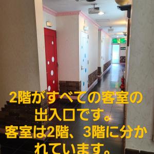 a sign in a hallway of a building with a staircase at ホテルコメット in Kurashiki
