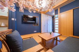 a living room with blue walls and a wooden table at 桜 Sakura Villa 4LDKの大きなお部屋 最大15名 in Osaka