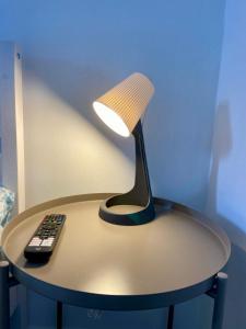 a lamp sitting on a table with a remote control at Monolocale 2 in Turin