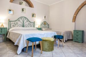 Un dormitorio con dos camas y dos taburetes azules. en Casal Toscano, en Casale Marittimo 60 fotos más