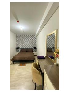 棉兰Podomoro Exclusive Pool View Apartment-5th Floor-Min 2N的带床和镜子的卧室 更多3张照片