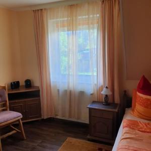 a bedroom with a window with a bed and a chair at Landhaus in Petersdorf in Funfseen