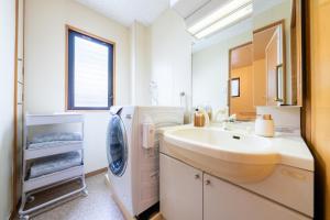 a bathroom with a sink and a washing machine at 桜 Sakura Villa 4LDKの大きなお部屋 最大15名 in Osaka +48 photos