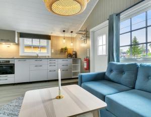 a living room with a blue couch and a table at Ballangen Camping in Narvik