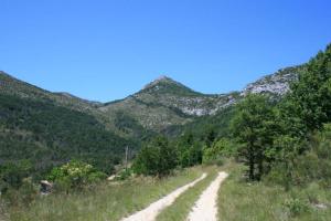 a dirt road with mountains in the background at Domaine de Cruvelet Petit gite in Trigance