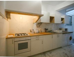 a kitchen with white cabinets and a stove top oven at Queluz Residence in Queluz