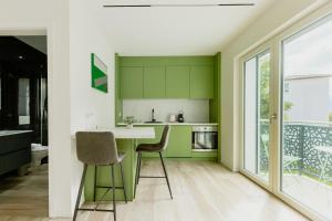 a kitchen with green cabinets and a table and chairs at Home Sofia Room 5, for Couples -By EasyLife Swiss in Lugano