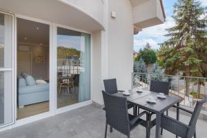 a patio with a table and chairs on a balcony at Dozsa Residence in Oradea