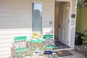 a patio with two chairs and a table with cake on it at Compact 1BR Studio, Fast Wi-Fi & Kitchenette, Great for Short Stays & Monthly Bookings in Little Marlow +17 photos