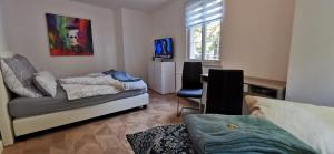 a bedroom with a bed and a desk and a chair at Apartment mit Parkblick Lindau Bodensee Insel in Lindau +9 photos