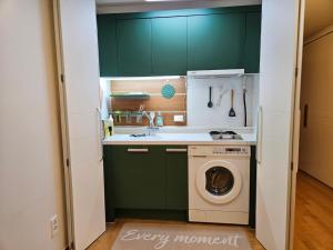 ソウルにあるGangnam Yeoksam Station Full-option Remodeling New Houseのキッチン(緑のキャビネット、洗濯機付)