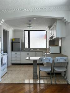 uma cozinha com mesa e cadeiras e uma janela em Suite amoblada con aparcamiento privado excelente vista y ubicación! Sector La Carolina em Quito