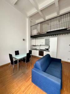 Una sala de estar con un sofá azul y una mesa. en loft industrial revival, en Milán