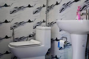 a bathroom with a white toilet and a sink at Lakeland Homestay Diphu in Diphu +24 photos