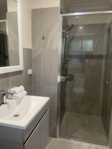 a bathroom with a glass shower and a sink at The Old Rose Farm House in Eurobin +33 photos
