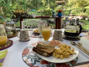 a table with a plate of food and orange juice at PaloSanto, Casa Rural in Jardin