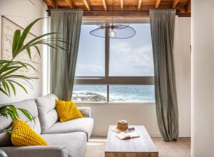 un soggiorno con un divano e una grande finestra di Calima de Jover a La Laguna