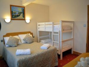 
a bed room with two beds and a desk at Gatwick Cambridge Hotel in Horley
